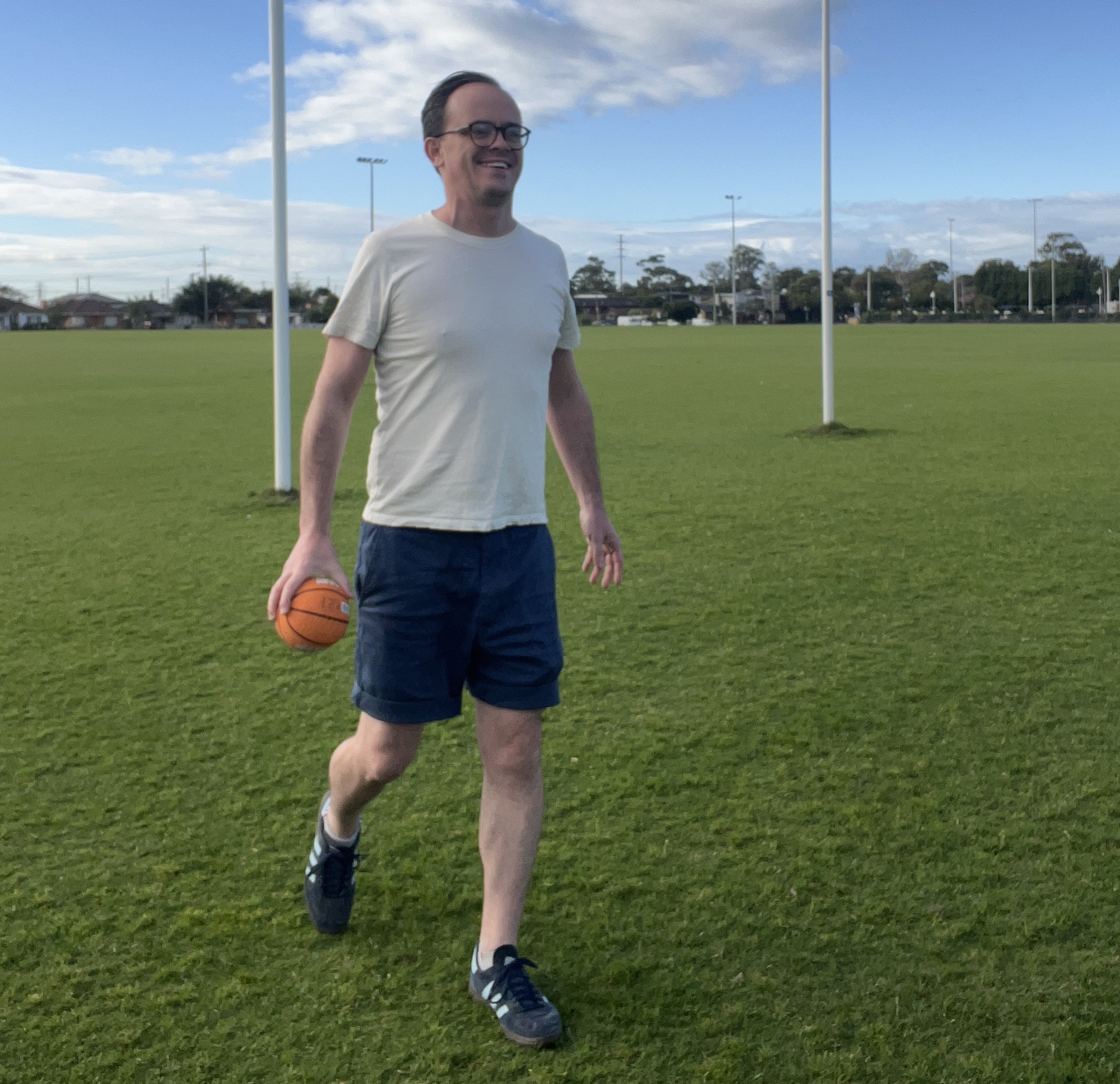 Maximilien holding a ball on a park field
